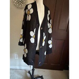 Long black cardigan with smiling white daisies with yellow faces Says M, fits li